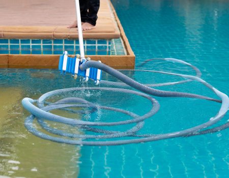 Worker cleaning swimming pool with vacuum tube in the morning. Worker cleaning swimming pool with vacuum tube in the morning